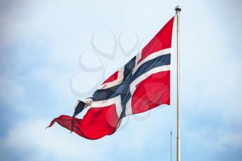 Flag of Norway waving over cloudy sky background