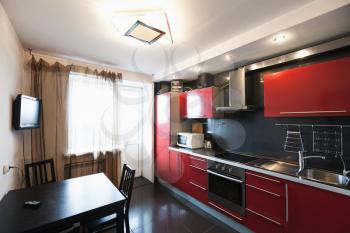 Modern kitchen room interior with tv. Black, red and white design