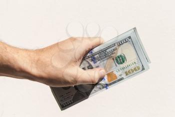 US dollars notes in male hand over gray background