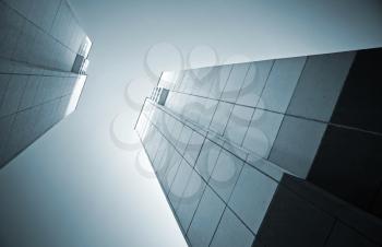 Looking up in the city. Abstract architecture monochrome background with two tall concrete walls opposite