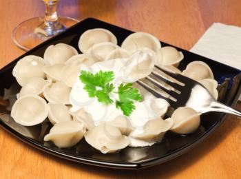 Pelmeni (meat dumplings) with sour cream. Modern traditional daily Russian cuisine