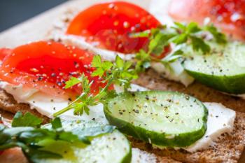 Healthy food, breakfast sandwiches. Finnish rye crisp bread, soft cheese, cucumber, tomato, parsley and black pepper