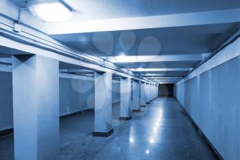 Underground passage interior with lights and concrete columns 