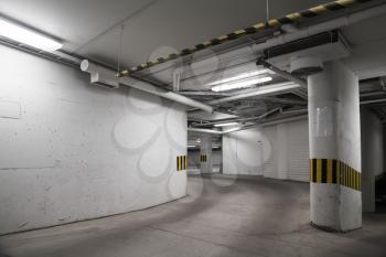 Empty underground parking interior, concrete walls and columns 