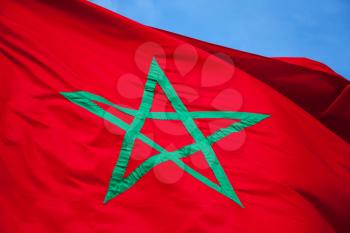 National flag of Morocco above clear blue sky