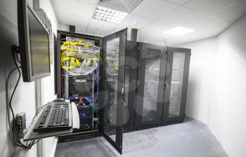 Modern server room interior with black computer cabinets and user terminal