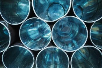 Abstract industrial background, empty blue shining metal tubes with perspective effect