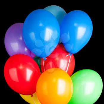 Group of colorful balloons on ribbons isolated on black background