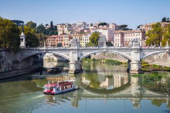 Small touristic boat goes to Ponte Vittorio Emanuele II. It is a bridge in Rome constructed to designs of 1886 by the architect Ennio De Rossi