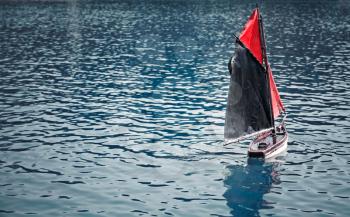 Traditional small wooden sailing boat in the pond of park Jardin du Luxembourg, Paris, France