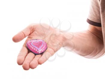 Handmade heart shaped stone as a gift in man's hand isolated on white