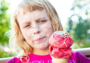 Little girl with big fruit ice-cream in the park. Selective focus