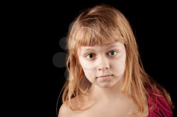 Closeup studio portrait of blond Caucasian little girl on black
