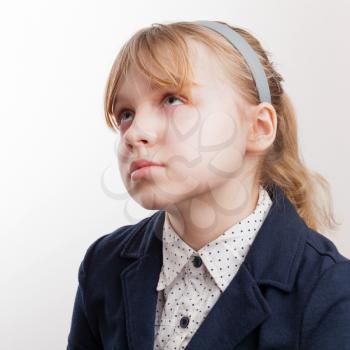 Closeup portrait of blond Caucasian thinking schoolgirl  on white background