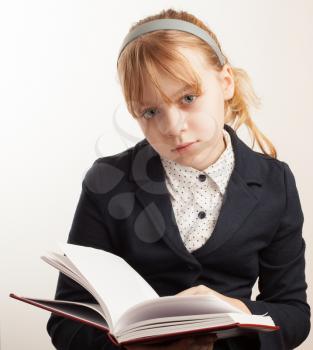 Closeup portrait of blond Caucasian schoolgirl with book