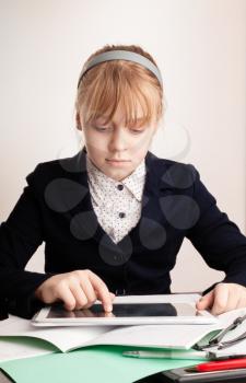 Little blond girl with tablet device in school
