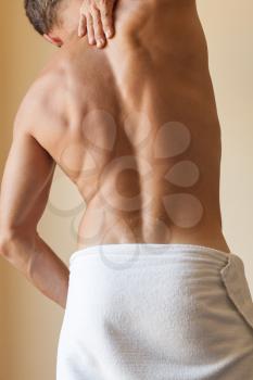 Back of Strong young Caucasian man with white towel