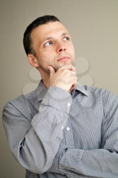 Serious thinking young Caucasian man, casual studio portrait
