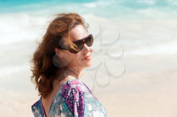 Young beautiful Caucasian woman in sunglasses. Summer outdoor portrait on the sea coast