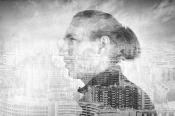 Profile portrait of young man combined with modern cityscape under cloudy sky, double exposure photo effect