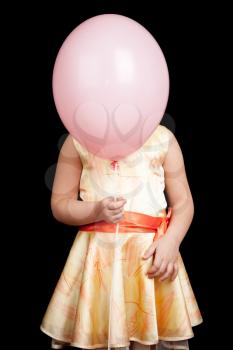 Caucasian little girl hides her face under pink balloon