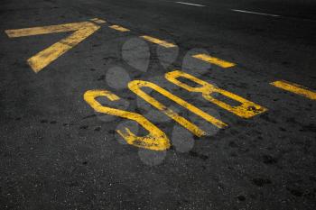 Yellow bus stop marking on urban asphalt road