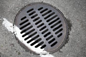 Round hatch and white dividing line on urban asphalt road