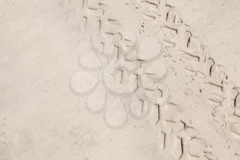 ATV tracks on the white sand beach. Closeup photo