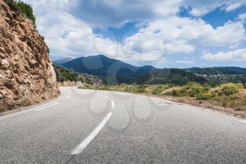 Turning mountain road with dividing line on asphalt, landscape of Corsica, France