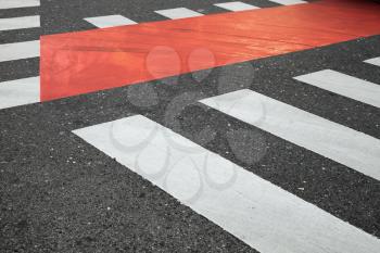 Dark gray asphalt road with white and red pedestrian crossing road marking zebra, abstract transportation background