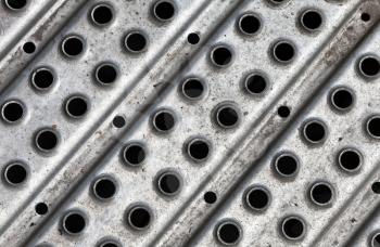 Closeup texture of footbridge metal plate with holes