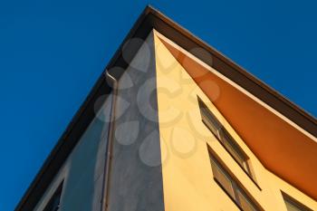 Abstract fragment of contemporary architecture, yellow walls under deep blue sky