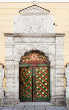 Ancient colorful wooden door with decoration elements in old building facade. Tallinn, Estonia