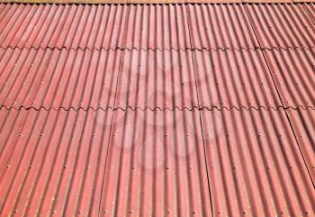 Red roof made of corrugated cardboard bituminous, background photo texture with perspective effect