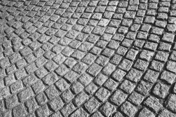 Gray cobblestone street pavement with round pattern, urban background texture