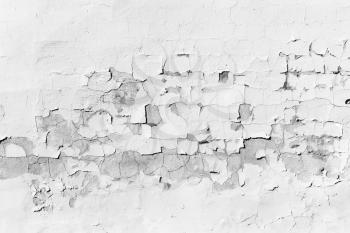 Background texture of old concrete wall with peeling layer of white paint