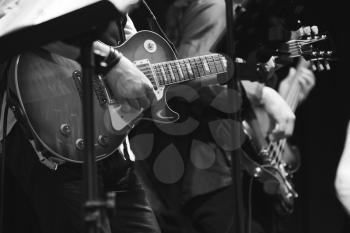 Rock and roll music background, guitar players on a stage, selective focus