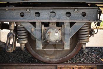 Dark railway carriage wheel with suspension details, closeup frontal photo