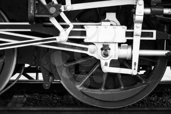 Wheels of steam locomotive with the power parts, stylized black and white photo