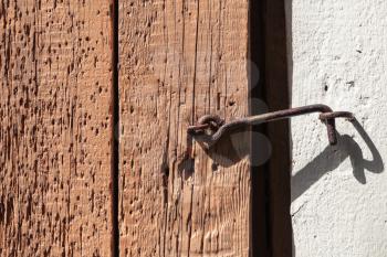 Old rusted latch hook on rough wooden door