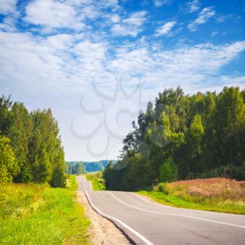 Blue cloudy sky and empty rural highway perspective in summer day, European road, square landscape
