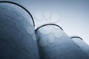 Abstract industrial architecture fragment, large tanks made of concrete for storage of bulk materials, blue toned photo