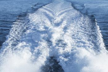 Fast motor boat wake over blue sea water