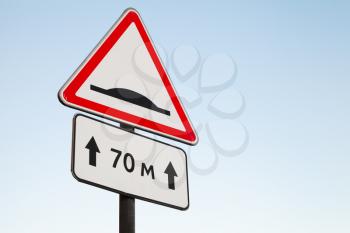 Speed Bump. Warning road sign over bright blue sky background
