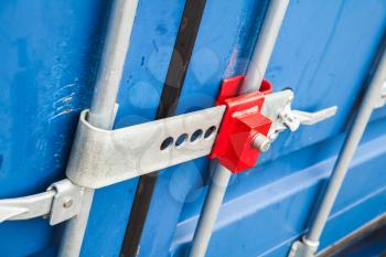 Red lock on the gate of standard blue cargo container for shipping transportation