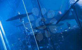 Blue musical photo background, rock drum set on dark stage with cymbals