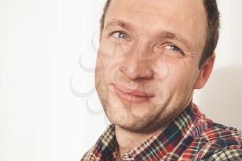 Close up studio portrait of smiling young adult Caucasian man in colorful casual shirt