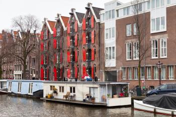 Colorful traditional living houses and houseboats along the canal in Amsterdam, Netherlands. Warm vintage tonal correction filter effect, retro style