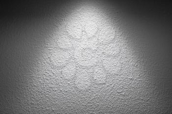 White wall with decorative plastering relief pattern and spotlight illumination, background photo texture