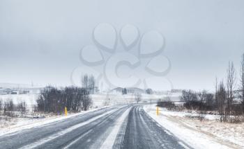 Snowy Icelandic road perspective, empty rural landscape